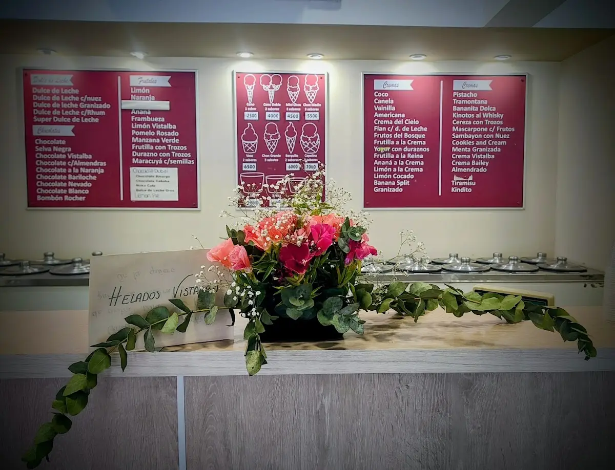 Mostrador de Helados Vistalba con un arreglo de flores y las pizarras de sabores